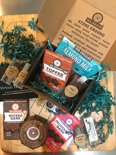 An opened box of Taza Chocolates shows items available in the virtual tasting kit, including bars, discs, nibs, and pouches. These help provide an engaging virtual tourism experience for participants.
