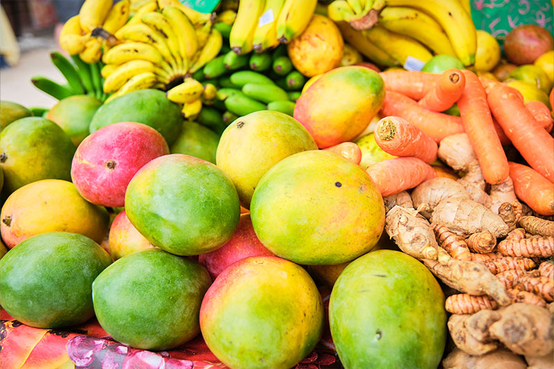 mangoes, ginger root, bananas at a street market table