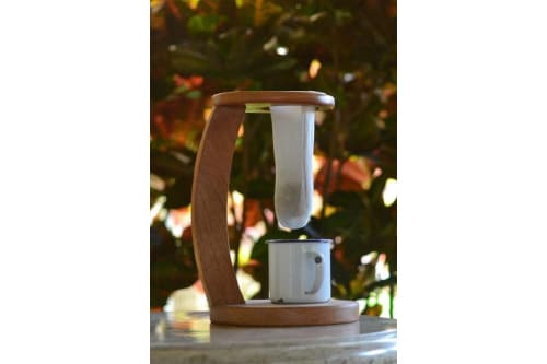 A traditional coffee maker with a wooden arm and white mesh strainer, showing that hotel amenities can have marketing value.