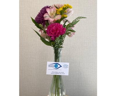 A vase of pink, purple, and yellow flowers, which is a surgical recovery gift from ModernEyes Opthalmology.