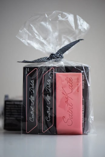 Image of a brown box with a pink rectangular bar of soap in front that looks like an eraser from the Saint Kate hotel in Milwaukee. It's a great example of how small touches can make a big impact in hospitality.